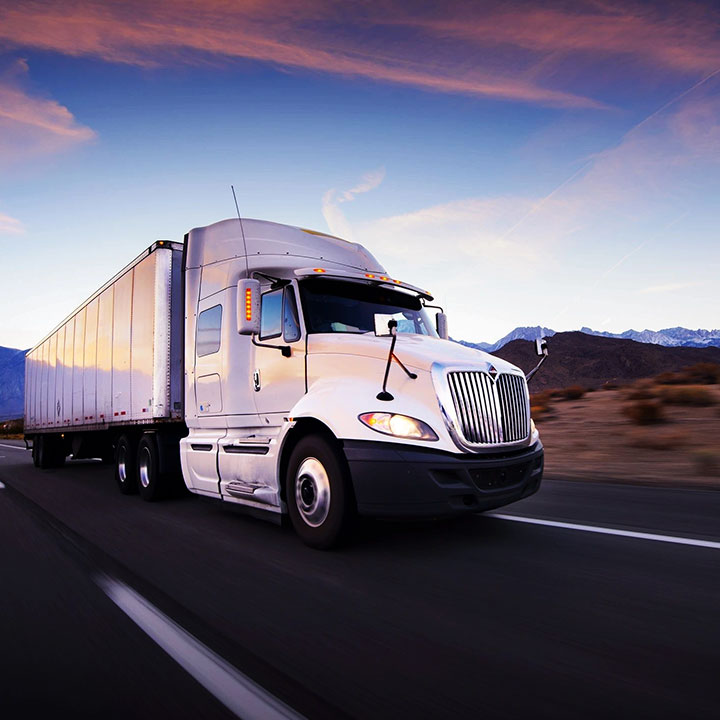 A white semi truck driving down the road.